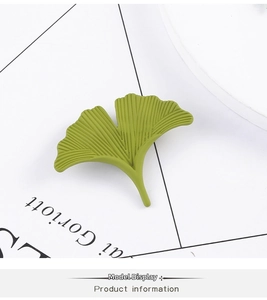 Detailed view of matte green ginkgo leaf brooch with realistic radial vein textures