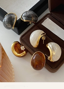 Detailed macro view of vintage resin earrings with gold-plated metal trim in three colors