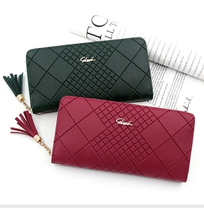 Close-up of green and red long purses featuring geometric diamond texture and tassels
