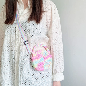 Close-up of kids rainbow silicone pop-it bag with heart bubbles and striped strap