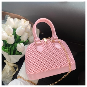 Detailed shot of a pink PVC jelly shell bag with gold hardware and chain strap