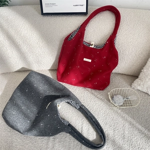 Détail du sac cabas à motif étoiles avec doublure à carreaux et options rouge et gris