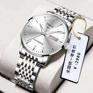 Detail view of silver men's automatic watch with day-date display and steel strap