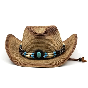 Dettaglio cappello da cowboy in paglia con fascia di perline turchesi e sottogola