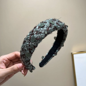 Detail of tweed headband with gray-green and dark red weaving and green sequins