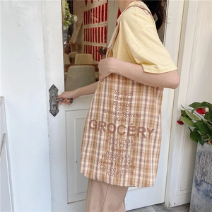 Plaid canvas tote bag with grocery text print for women in a casual lifestyle setting
