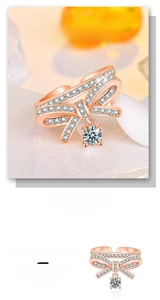 Macro shot of rose gold bow ring with pavé diamonds and a sparkling crystal drop detail