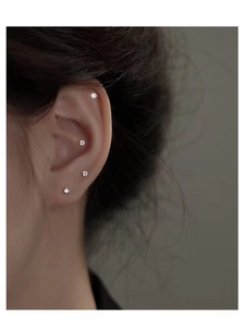 Close-up of minimalist S999 silver studs with sparkling cubic zirconia on a model's ear