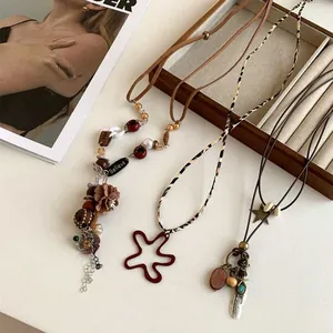 Detailed macro shot of bohemian star and feather necklaces with vintage beaded textures