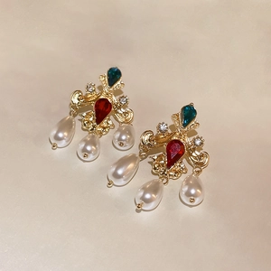 Detailed close-up of retro gold earrings with colorful rhinestones and pearl tassels