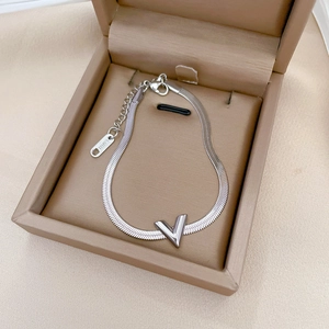 Macro detail of silver V-shaped pendant on stainless steel snake chain with adjustable clasp