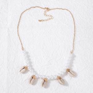 Detailed macro view of golden starfish and seashell pendants with white pearls on a necklace