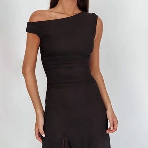 Detail view of elegant black off-shoulder dress with slimming waist pleats and side slit