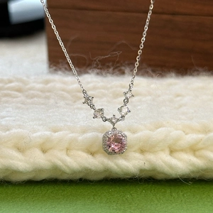 Macro shot of silver S925 necklace with pink square cubic zirconia on white knit