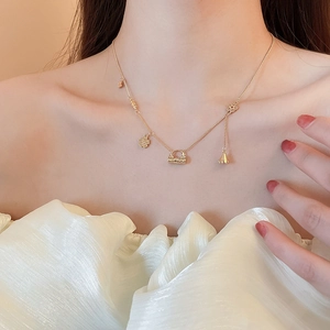Detail view of 18k gold plated flower and handbag charms on a dainty necklace chain