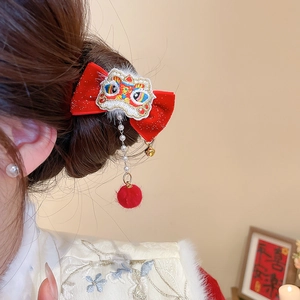 Detail of red lion dance bow hair clip with pearl tassels and bells worn on hair