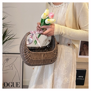 Detail of brown woven basket bag with pink silk scarf handle in elegant setting