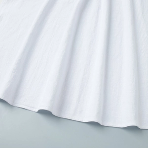 Detailed macro view of white cotton fabric texture with natural soft draping folds