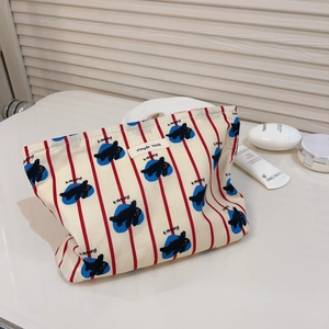 Détail de la trousse de toilette en coton rayé rouge avec motifs lapin et fermeture