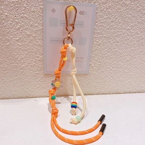 Détail d'un porte-clés en corde tressée avec fleur de soleil et perles colorées