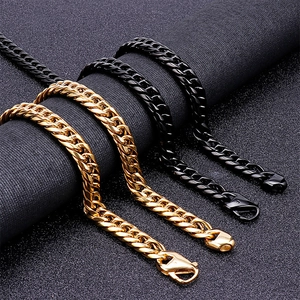 Polished stainless steel Cuban link necklaces in gold and black on textured fabric