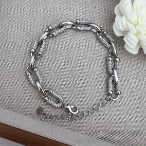 Detail of silver U-link chain bracelet with sparkling zircon stones and lobster clasp