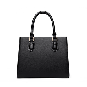 Minimalist black lychee texture handbag with golden hardware on white background