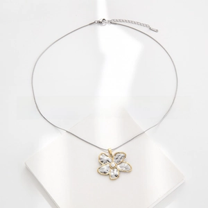 Detail of silver hammered flower necklace with gold trim and white pearl bead on snake chain