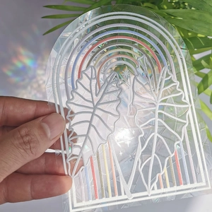 Detailed holographic suncatcher sticker featuring rainbow prisms and monstera leaf patterns