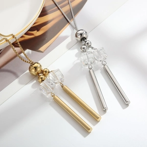 Detailed close-up of gold and silver long pendant necklaces with glass beads and metal tubes