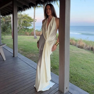 Détail d'une élégante robe longue en satin crème dos nu avec lien à la taille et fente haute