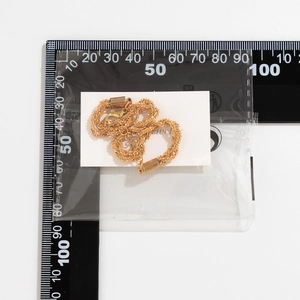 Close-up of a sparkling gold chain necklace with measurement scale for size reference