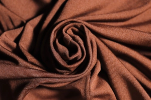 Vue détaillée du tissu en maille côtelée marron montrant la texture douce et élastique