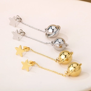 Detailed view of long star and planet dangle earrings in gold and silver finishes