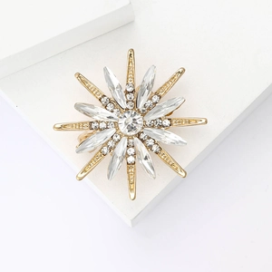 Elegant gold octagram brooch with sparkling marquise crystals on a white pedestal
