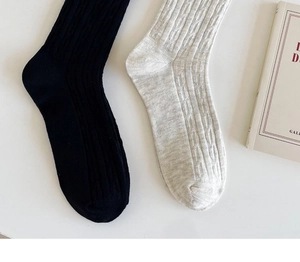 Texture de maille détaillée des chaussettes mi-hautes en coton noir et avoine
