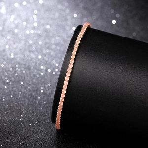 Close-up of a 2mm rose gold elastic bracelet with a single row of pink crystals on a stand