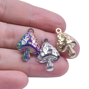 Macro shot of three stainless steel mushroom pendants in rainbow, silver, and gold finish