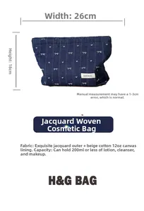 Detail view of denim bow cosmetic bag showing 26x18cm size and blue jacquard heart pattern