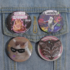 Detail view of four creative cartoon cat tinplate badges pinned on blue denim jacket fabric
