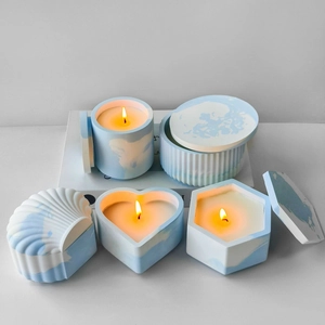 Set of four geometric marble concrete candle jars with matching lids on white surface