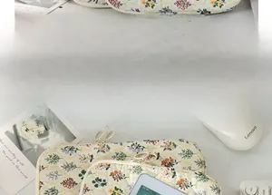 Quilted floral laptop sleeve with round metal zipper on a cozy desktop setting