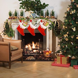 Detailed view of three festive red plush Christmas stockings hanging on a fireplace mantel