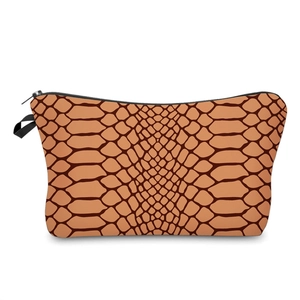 Detail shot of the snake skin pattern and black handle on this trapezoid cosmetic bag