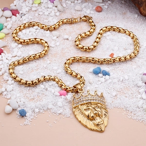 Detailed close-up of a golden lion head pendant with rhinestone crown on a box chain