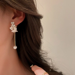 Orecchini a fiore con strass e perle indossati per un look elegante e raffinato