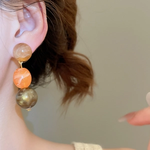 Detail of vintage geometric acrylic earrings with tri-color marble beads and gold links