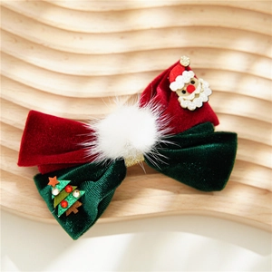 Close-up of velvet Christmas bow clips with Santa and tree motifs on a wooden base