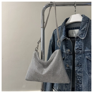 Detailed close-up of a silver rhinestone tote bag hanging on a chrome metal hanger