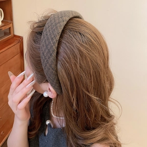 Dettaglio del cerchietto spesso in tweed grigio che mostra la trama del tessuto e il volume